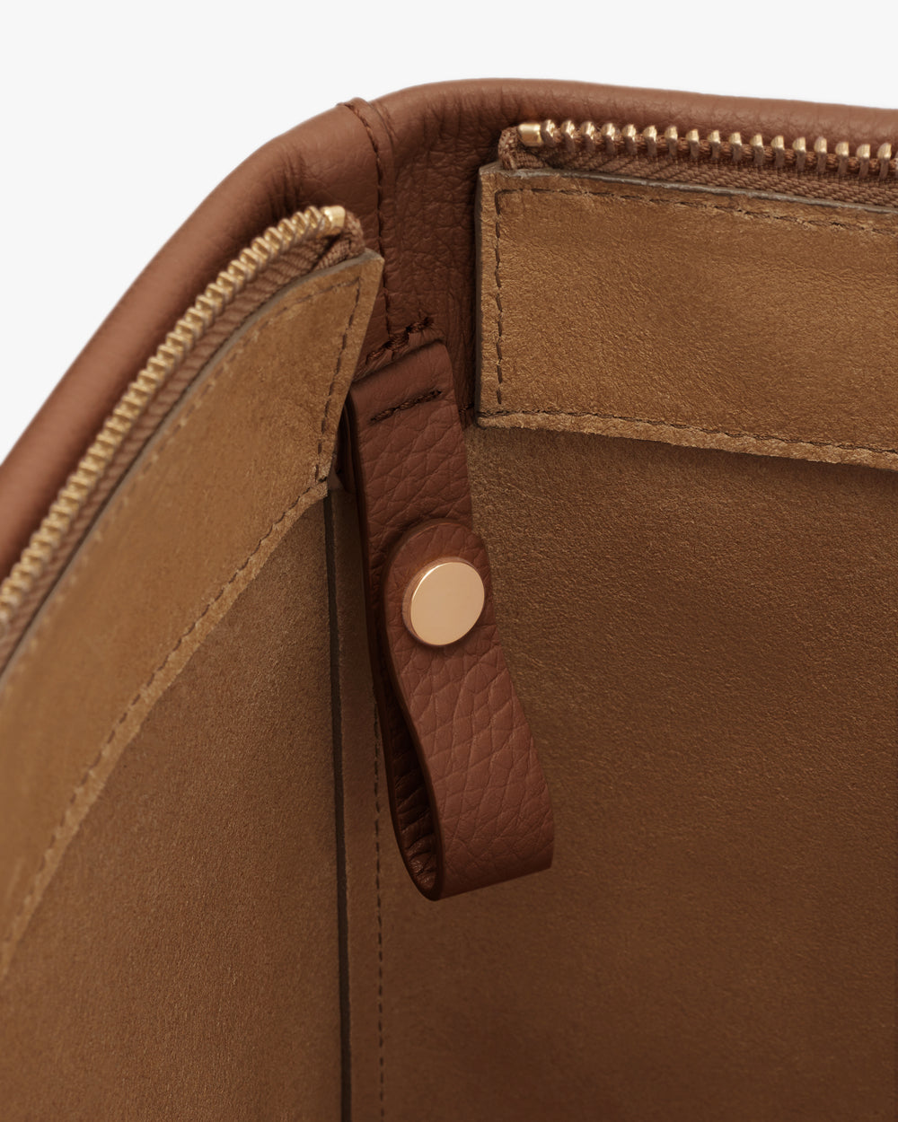 Open travel bag with zipper and leather strap detail.
