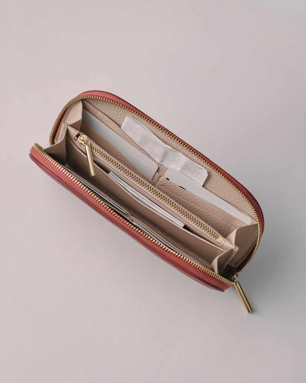 Open wallet with multiple compartments and a zipper.