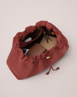 Open bag with keys, wallet, earbuds, and phone inside.