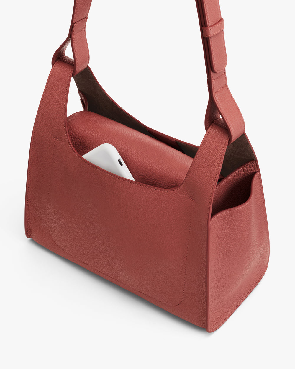 Shoulder bag with phone in outer pocket.