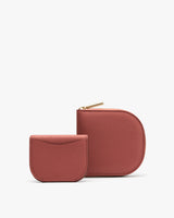 Two small wallets, one with a zipper, stand upright.