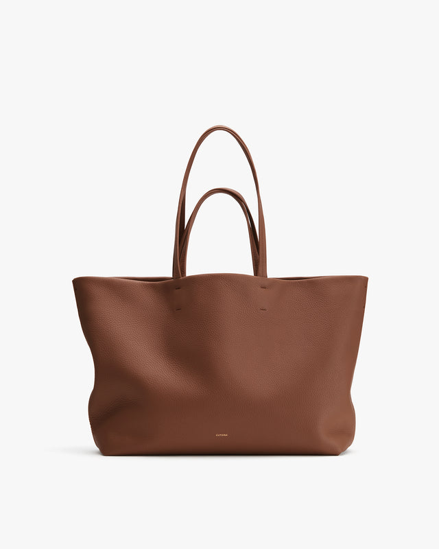 Large tote bag with two handles on plain background.