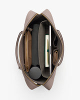Top view of open travel bag with various items neatly organized inside.