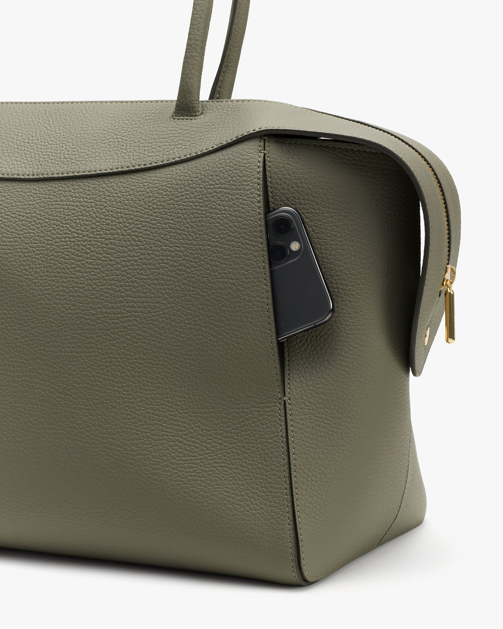 Travel bag with a phone in the side pocket, zipper visible.