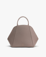 Geometric handbag with short handles on display.