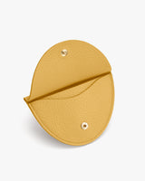 Round leather coin purse with snap button closure.