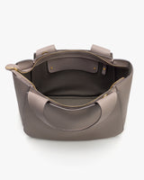 Open handbag with two handles and inner pockets visible.