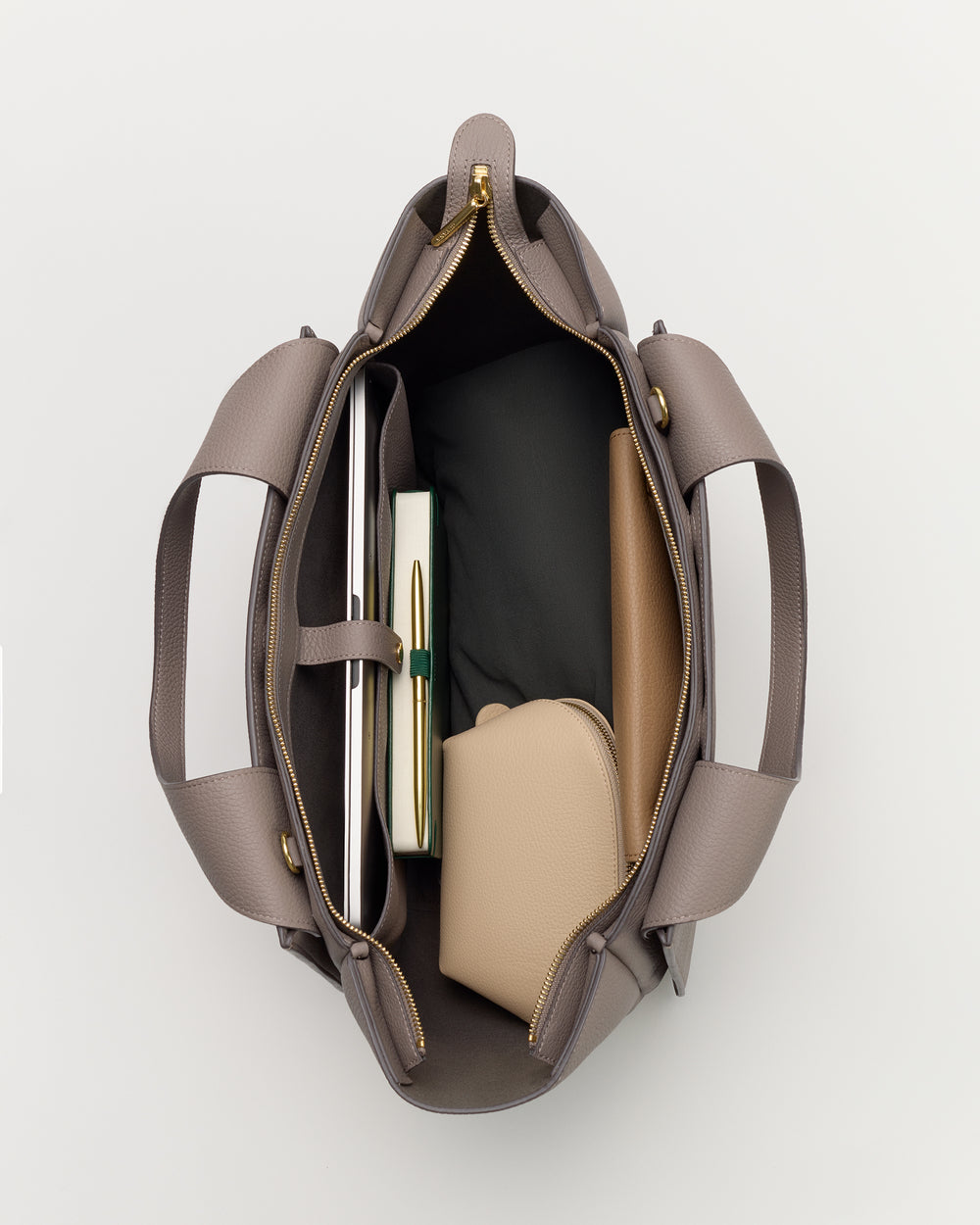 Open travel bag showing contents like books and a pouch inside.