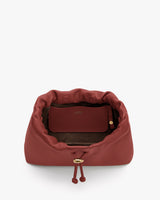 Open drawstring bag with visible interior pouch and button details.
