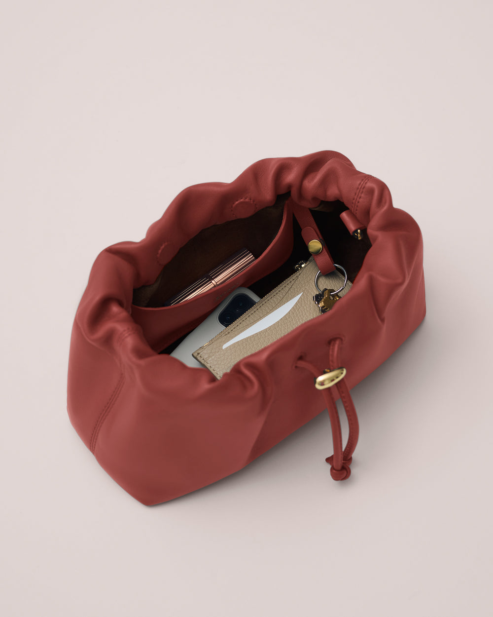 Open travel bag with phone, wallet, and keys inside.