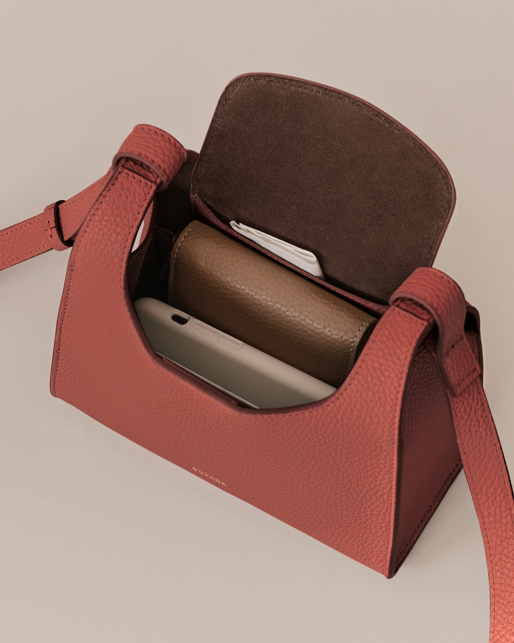 Open handbag with contents including a phone and a wallet inside.