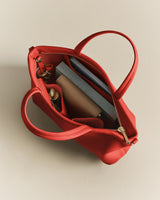 Open handbag with a notebook, wallet, and pen inside.
