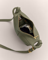 Open shoulder bag with visible keys and a compact inside.