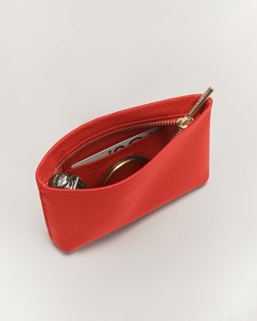 Small pouch with zipper, containing several small items.