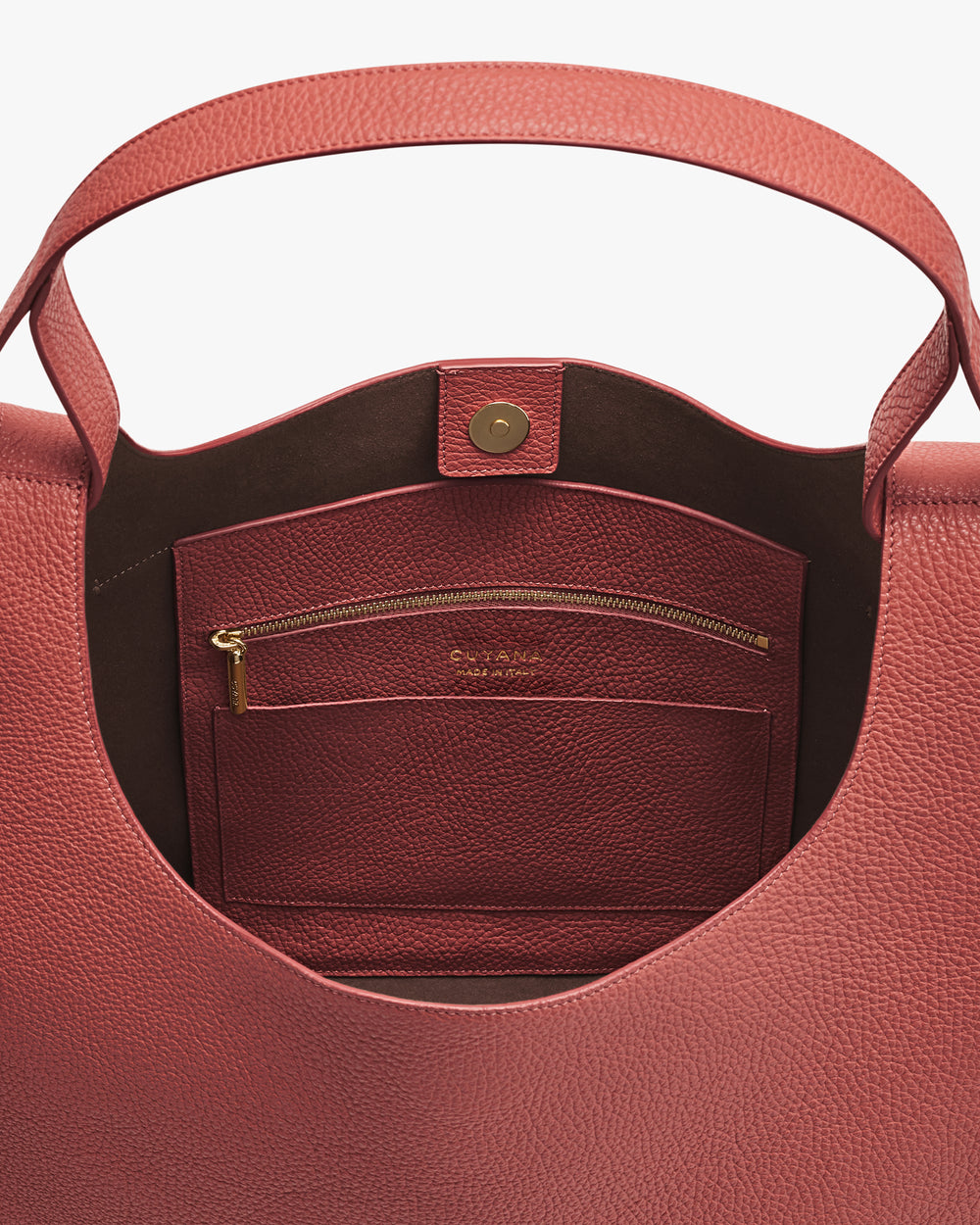Open handbag showing a pocket with a zipper and button clasp.
