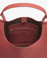Open handbag showing a pocket with a zipper and button clasp.