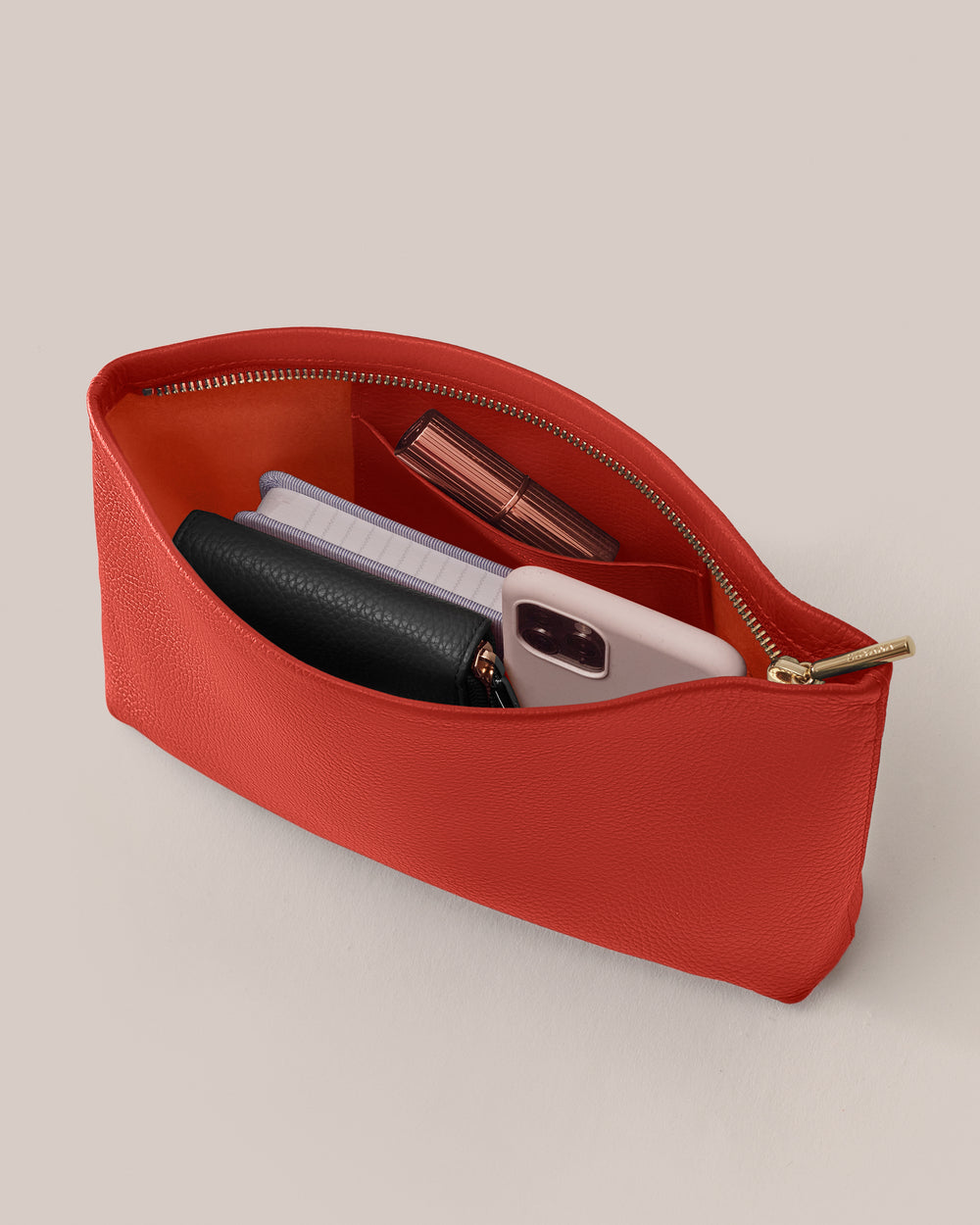 Open pouch with makeup, phone, and wallet inside.
