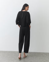 Person wearing a matching outfit and sandals, standing with their back to the camera.