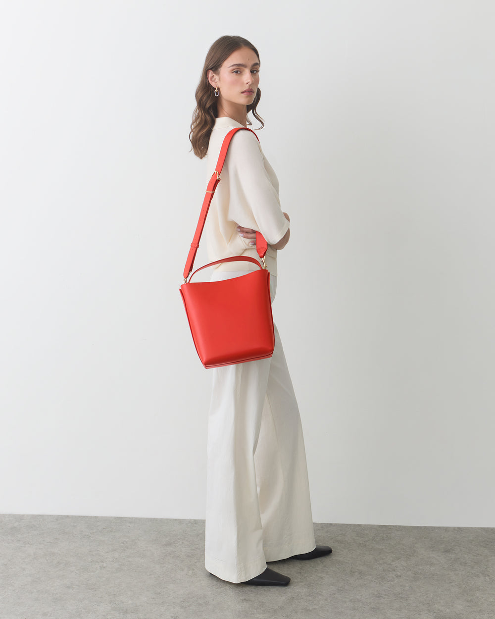 Woman wearing wide-leg pants and carrying a shoulder bag.