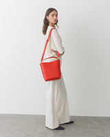 Woman wearing wide-leg pants and carrying a shoulder bag.