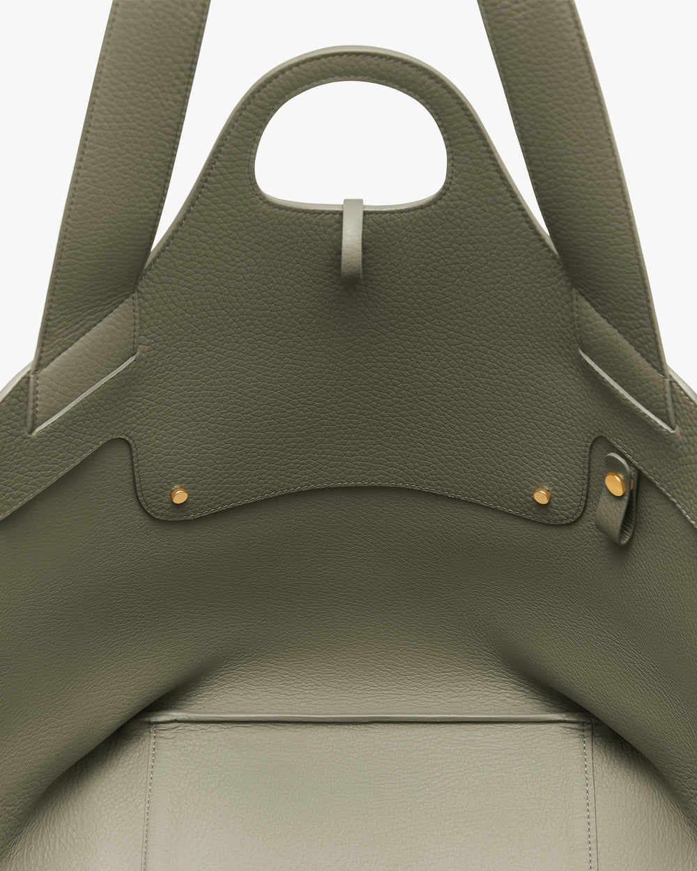 Close-up of a textured tote bag showing its handle and interior details with gold accents.