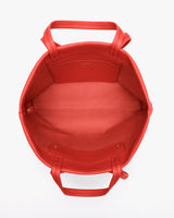 Open top view of a handbag with handles and inner pocket.