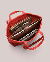 Open bag with organized contents, including a notebook, wallet, and tech accessories.