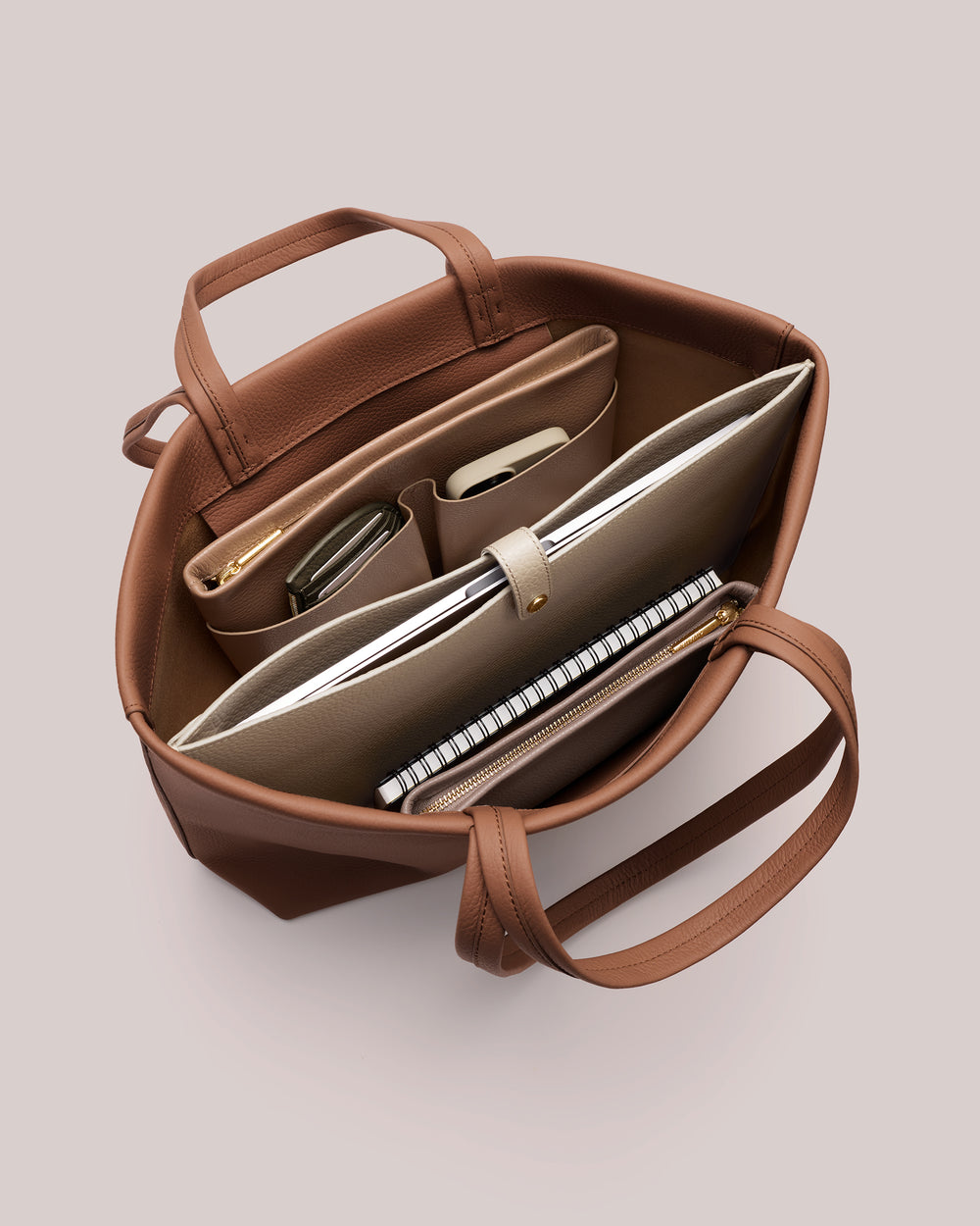 Open tote bag with organized compartments and items inside.