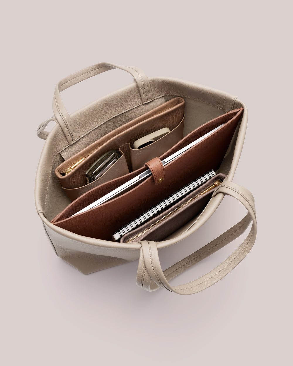 Open handbag with organized compartments and items inside.