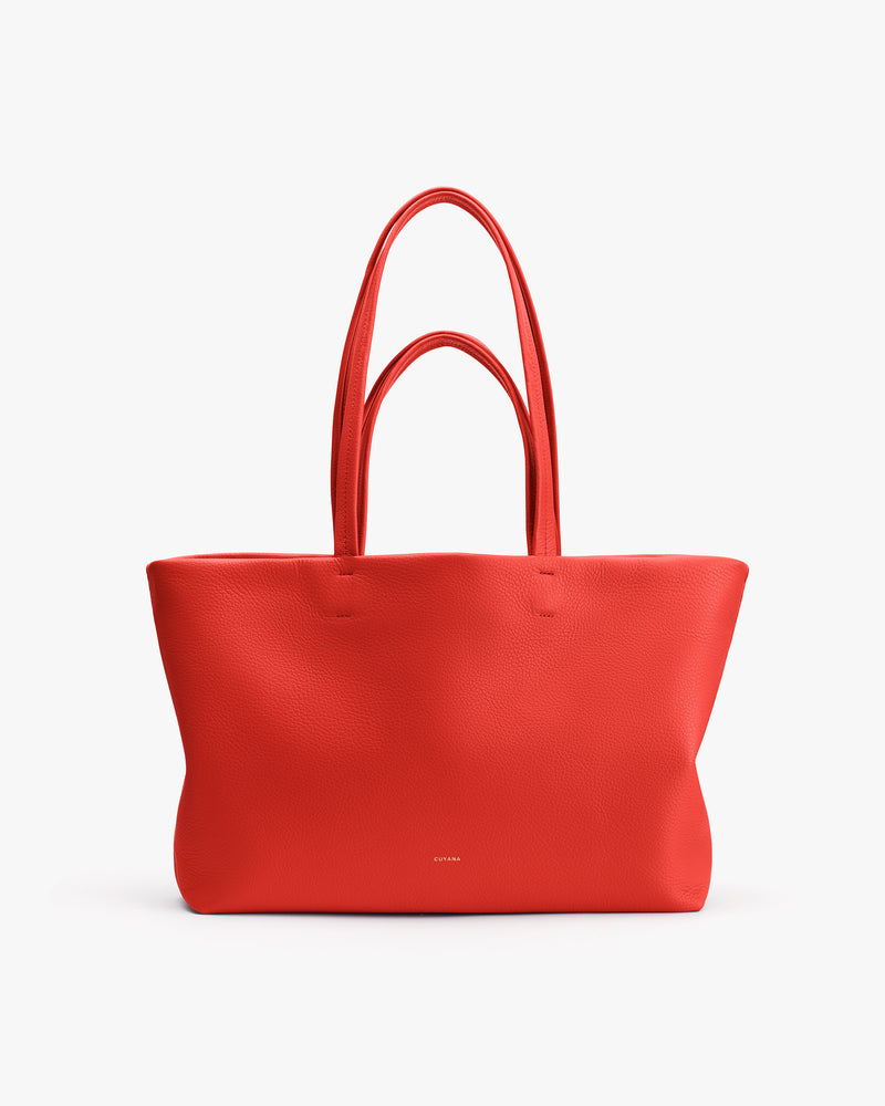 Tote bag with a smooth texture and long handles.