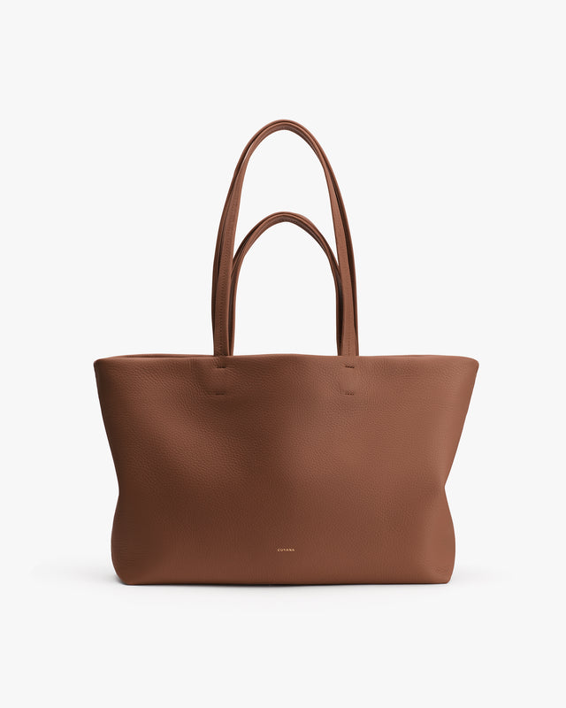 Large tote bag with minimalist design and long handles.