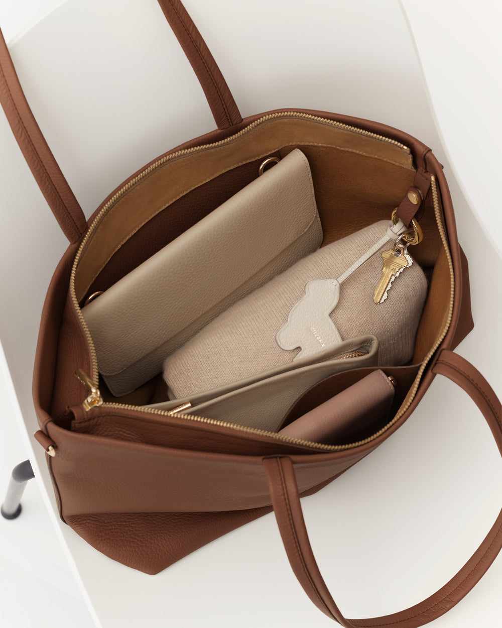 Open handbag with purses and a pair of keys inside.