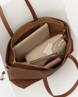 Open handbag with purses and a pair of keys inside.