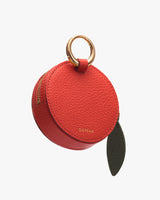 Round leather pouch with metal ring handle and zipper.