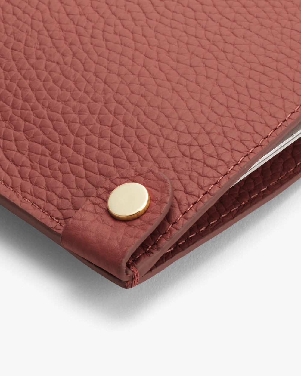 Close-up of a textured cover with a round metal button fastening.