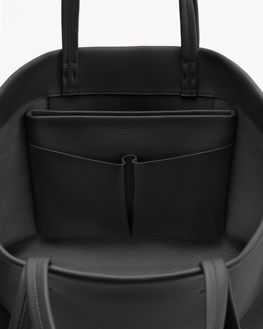 Open handbag showing inside pocket and straps.