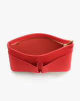 Open minimalist handbag with a visible zipper and curved design.