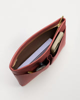 Open handbag with phone, notebook, and keys inside.