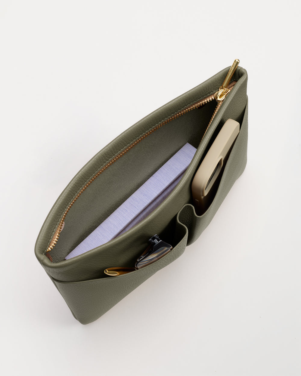 Open bag with book, phone, and sunglasses inside.