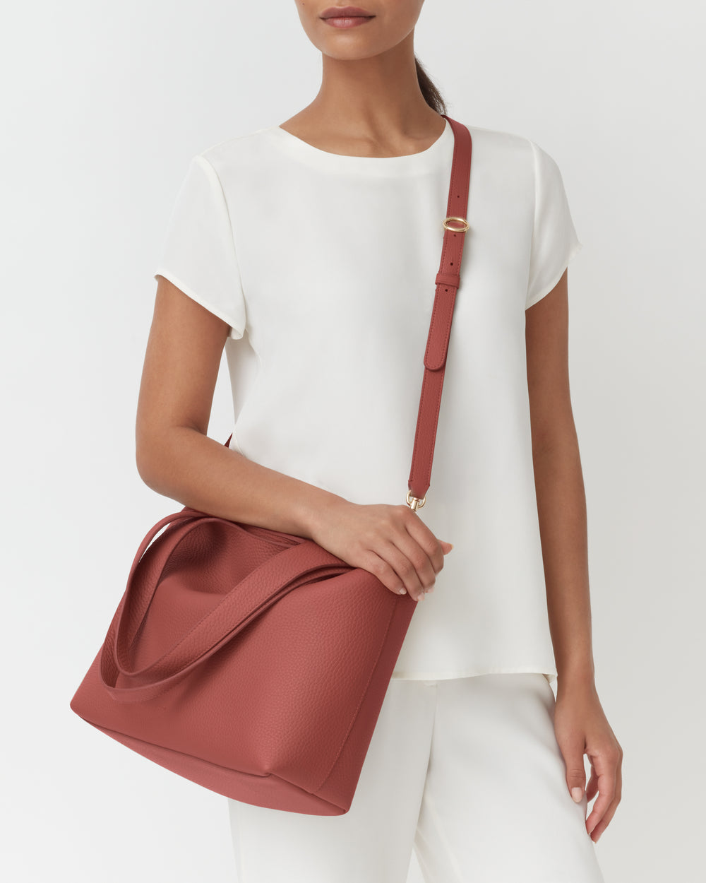Person with shoulder bag wearing a short-sleeved top.