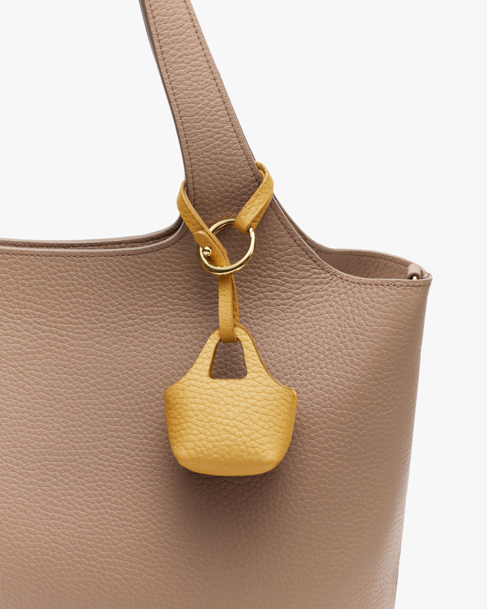 Large bag with small bag charm attached to handle.