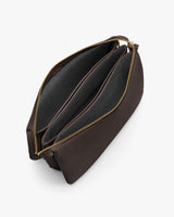 Open travel bag with multiple compartments and zippers, viewed from above.