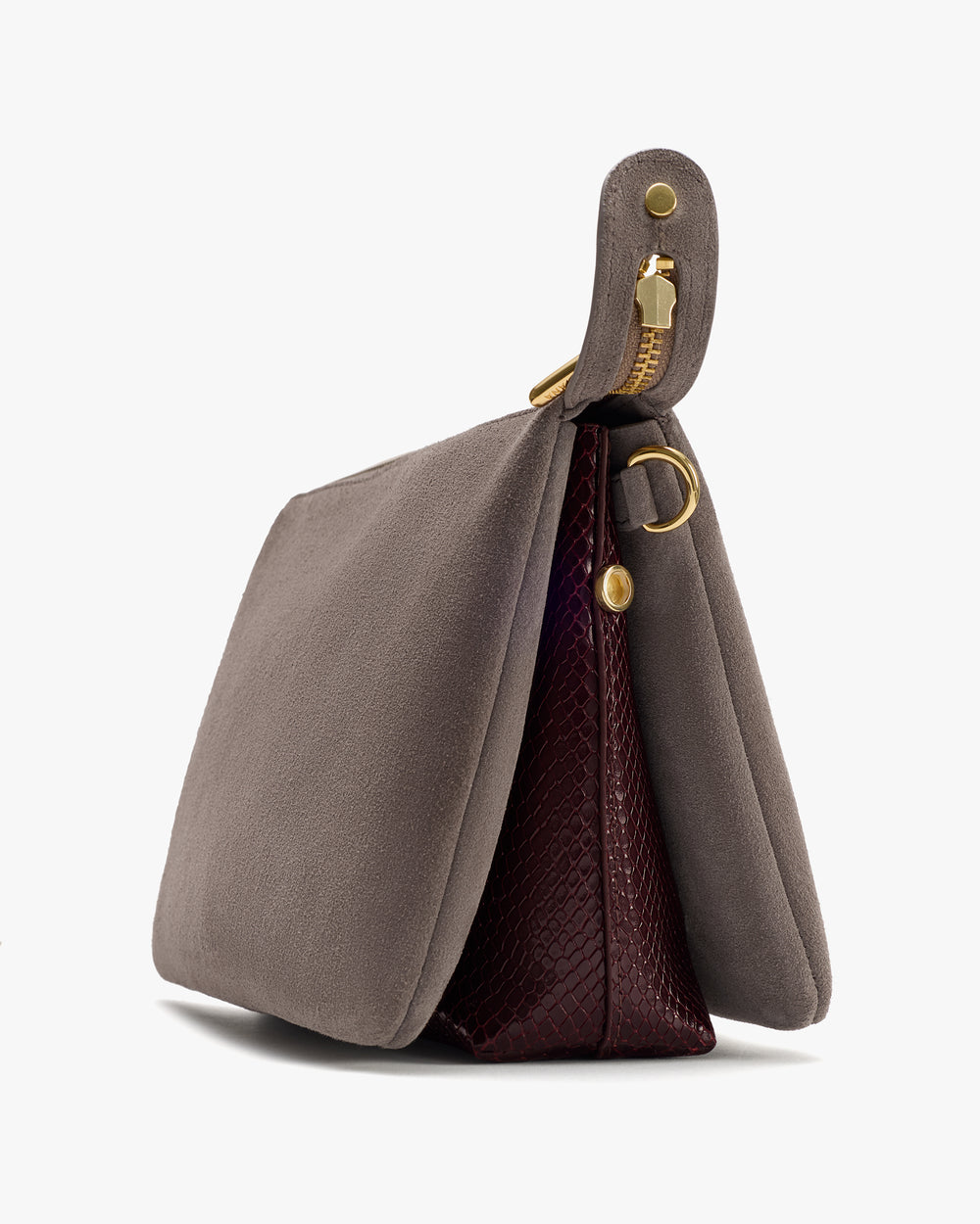 Side view of a handbag with a unique texture and gold-tone hardware.