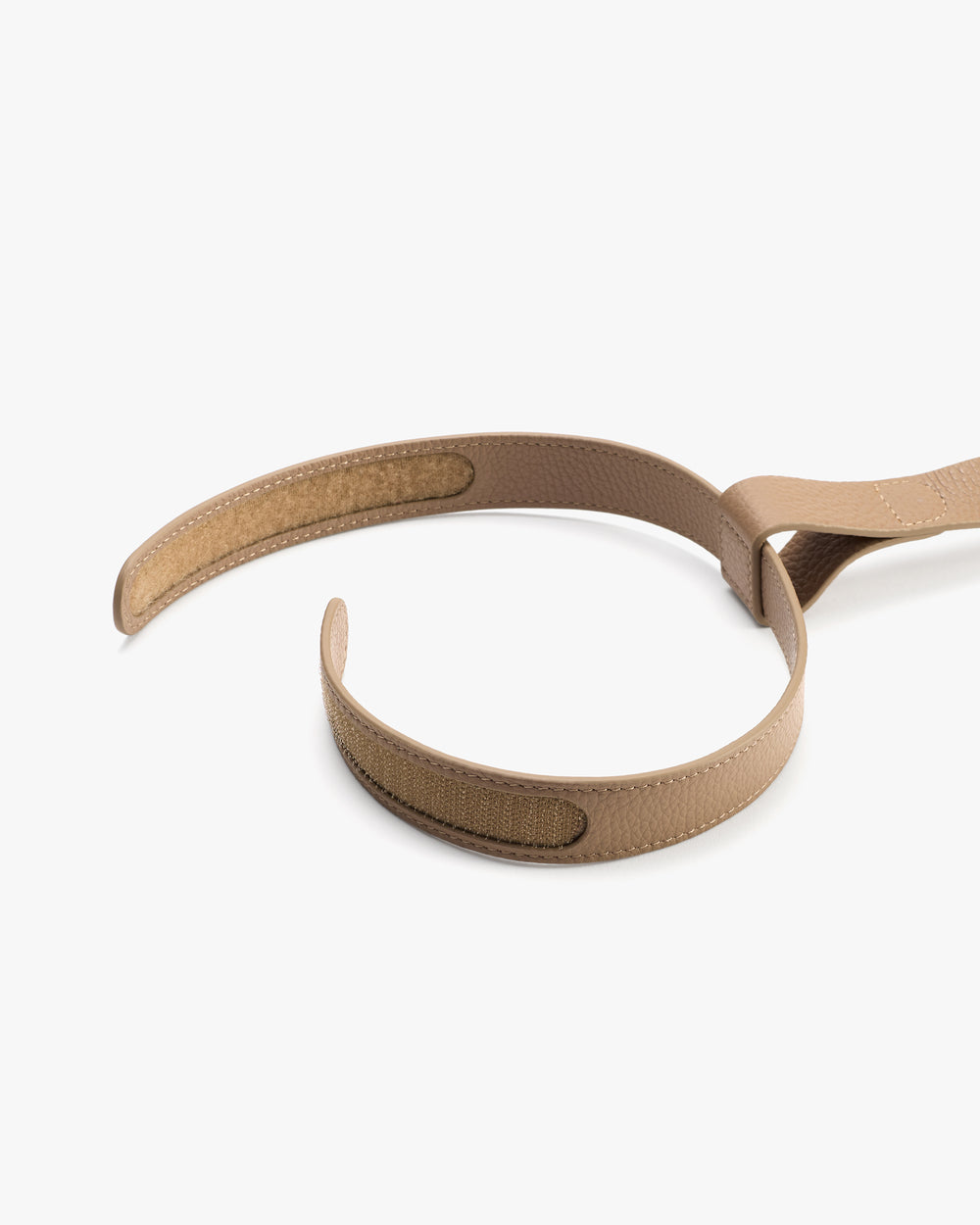Two curved straps with Velcro closures laid out on a surface.