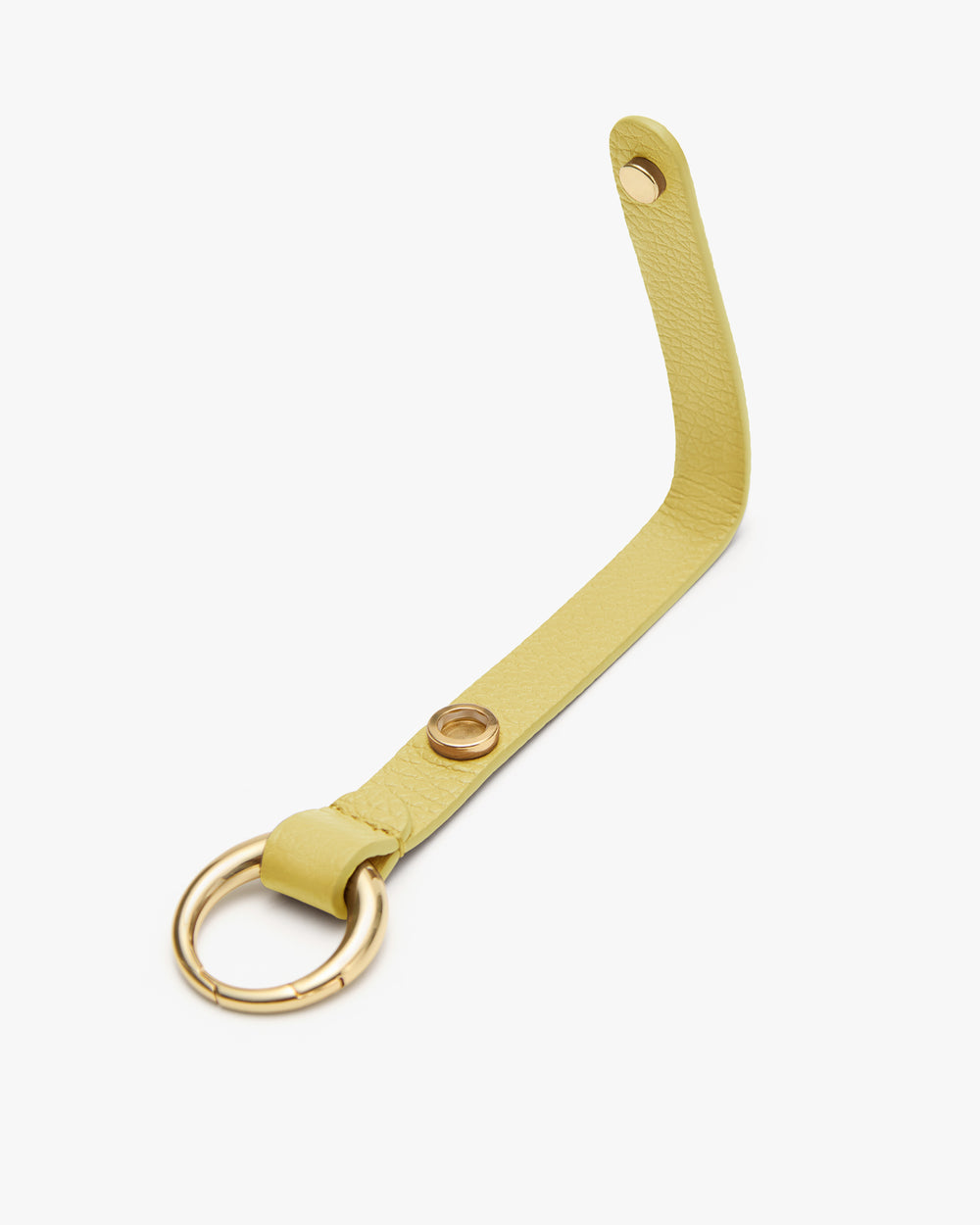 Leather strap with metal ring and buttonholes lying flat on surface.