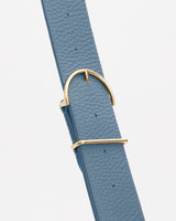 Close-up of a textured belt with a gold buckle.