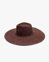 Wide-brimmed woven hat on a plain background.