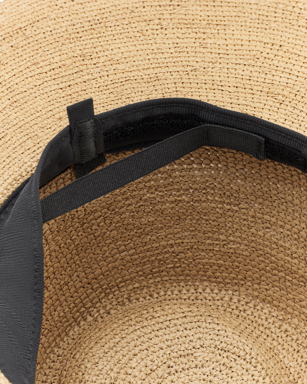 Inside view of a woven hat with an adjustable strap and band.
