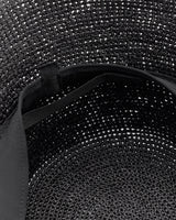 Close-up of an open woven bag with a visible strap inside.