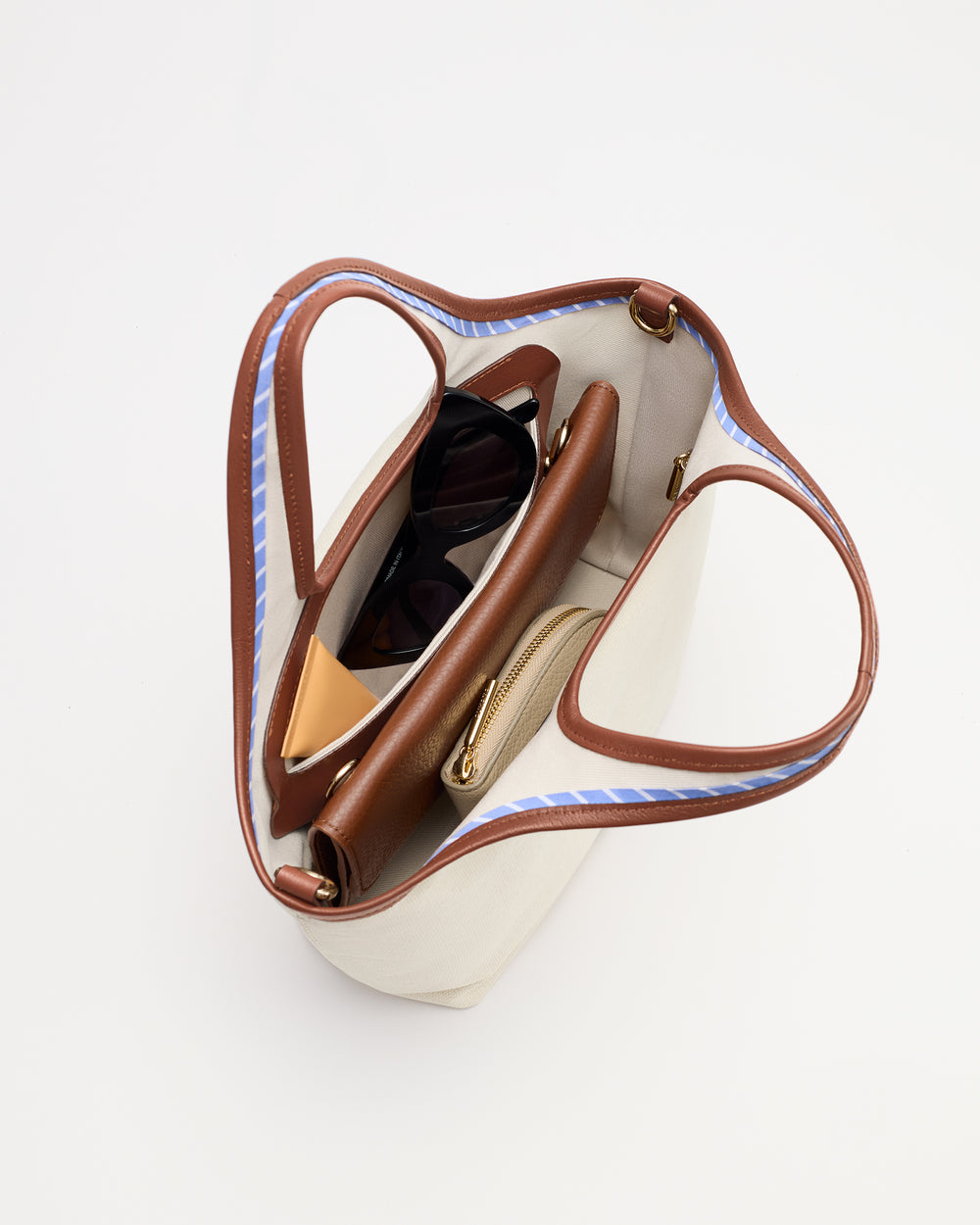 Open handbag containing sunglasses and a wallet viewed from above